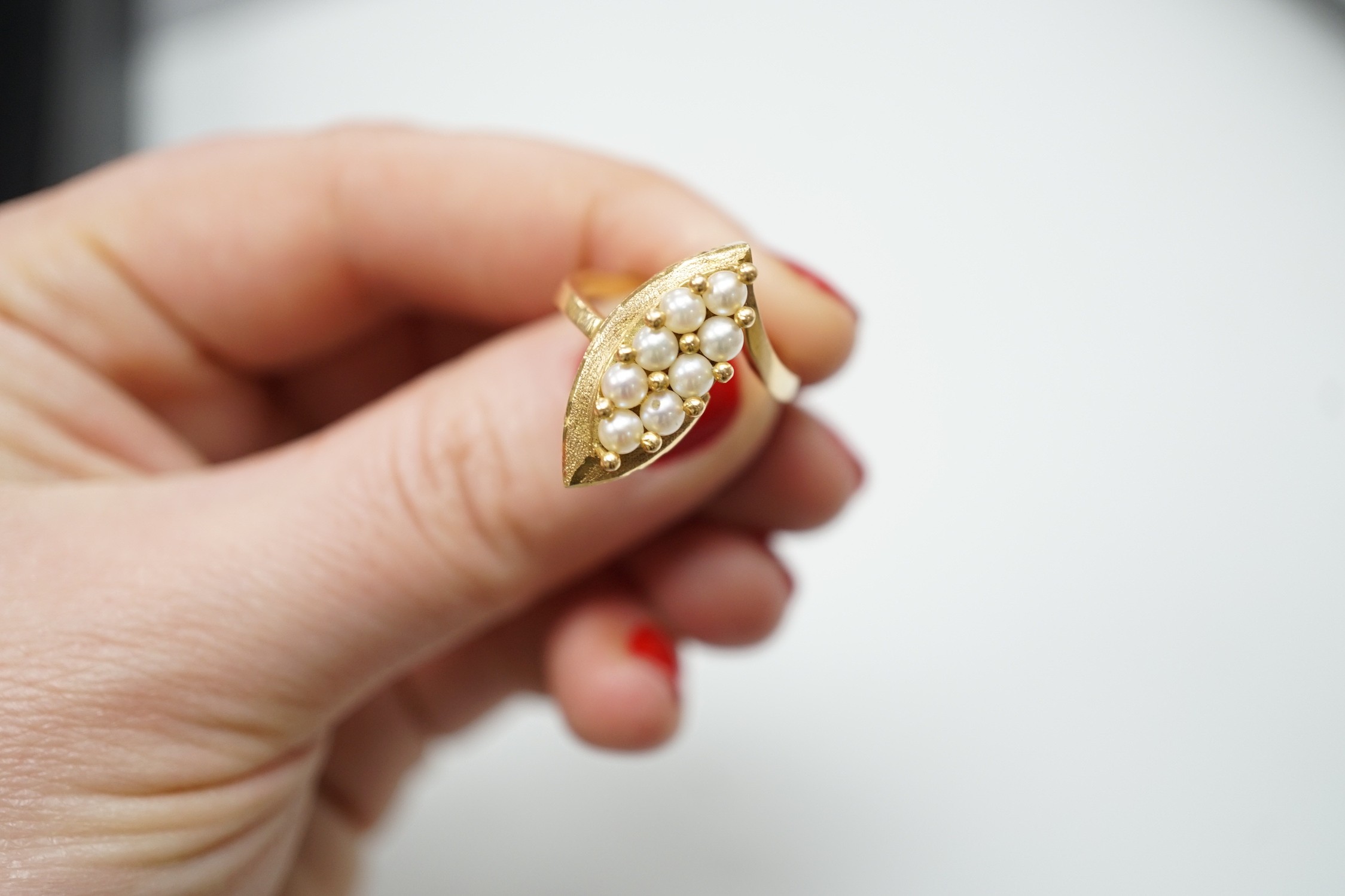 A modern continental yellow metal and seed pearl cluster set marquise shaped ring, size N